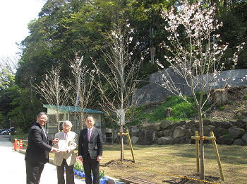 左から井口社長様、小川理事長様、田貝支店長<br>寄贈品:桜木