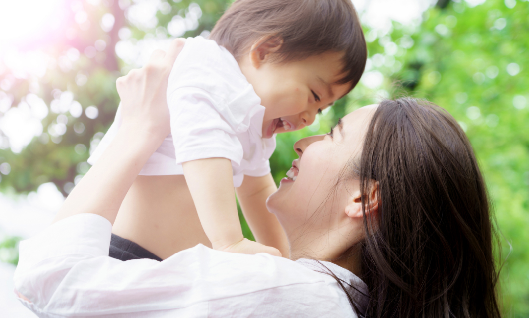 子供を高い高いする母親